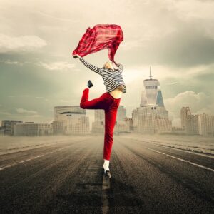 une femme pleine de joie de vivre danse sur la route