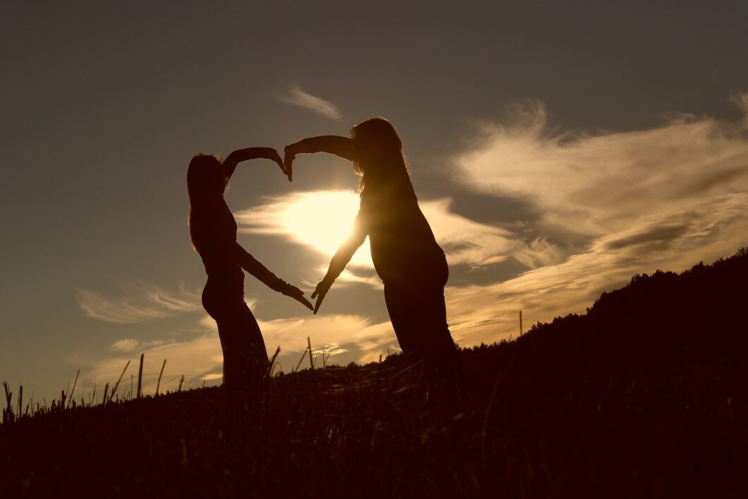 deux femmes forment un coeur avec leurs bras pour célébrer l'amour et l'amitié
