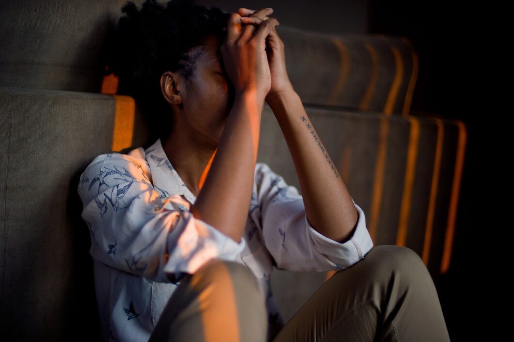 une femme assise par terre est triste et déprimée