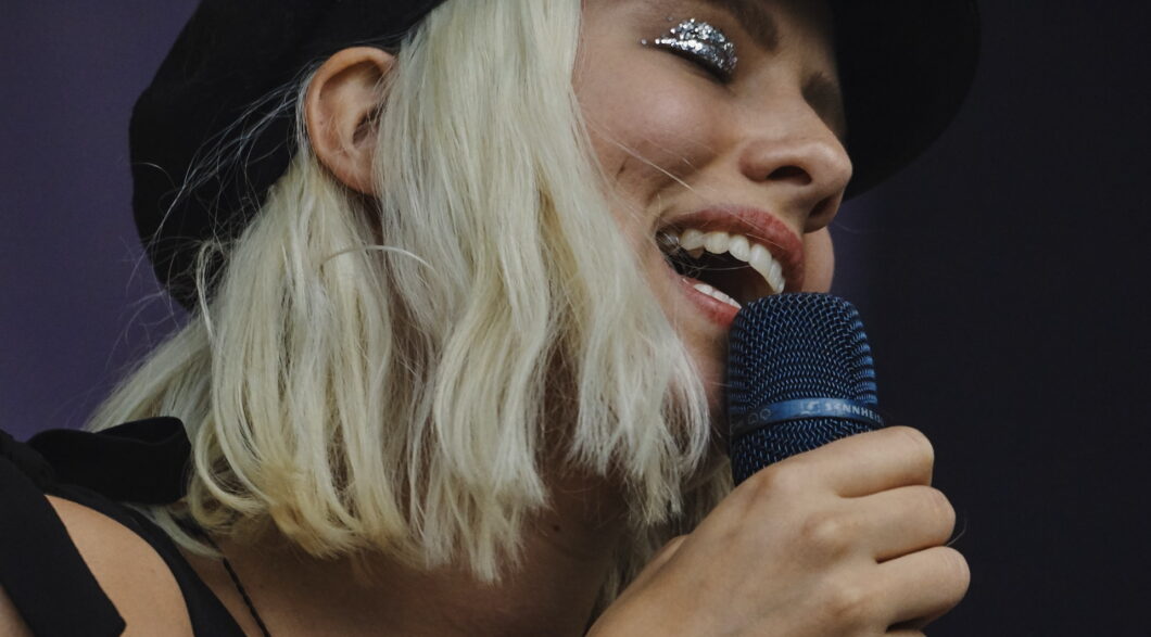 une chanteuse tient un micro dans la main et chante aisément et librement