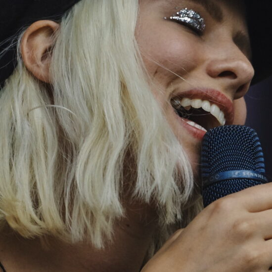 une chanteuse tient un micro dans la main et chante aisément et librement