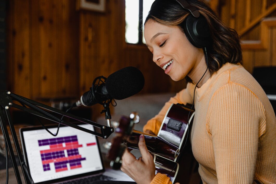 une chanteuse enregistre une chanson et joue de la guitare