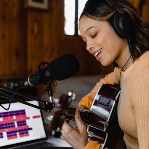 une chanteuse enregistre une chanson et joue de la guitare
