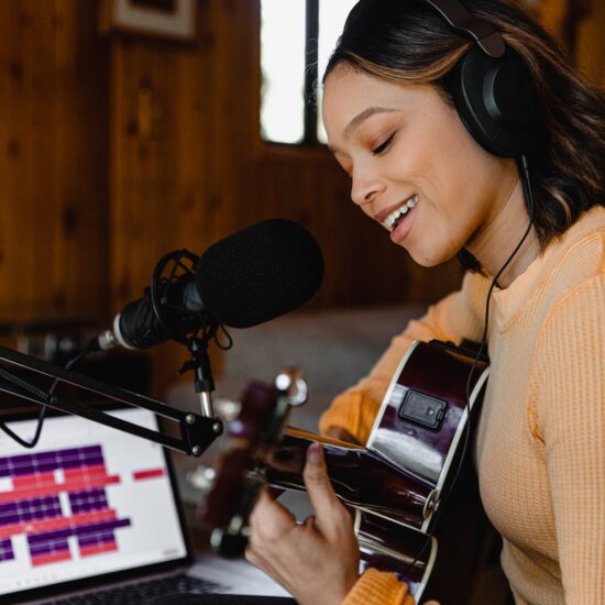 une chanteuse enregistre une chanson et joue de la guitare