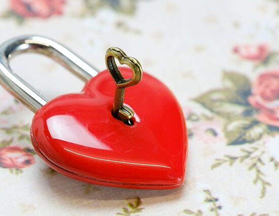 un cadenas en forme de coeur est ouvert avec une clé
