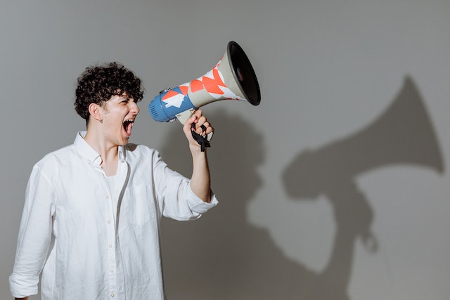 un homme parle fort à travers un mégaphone